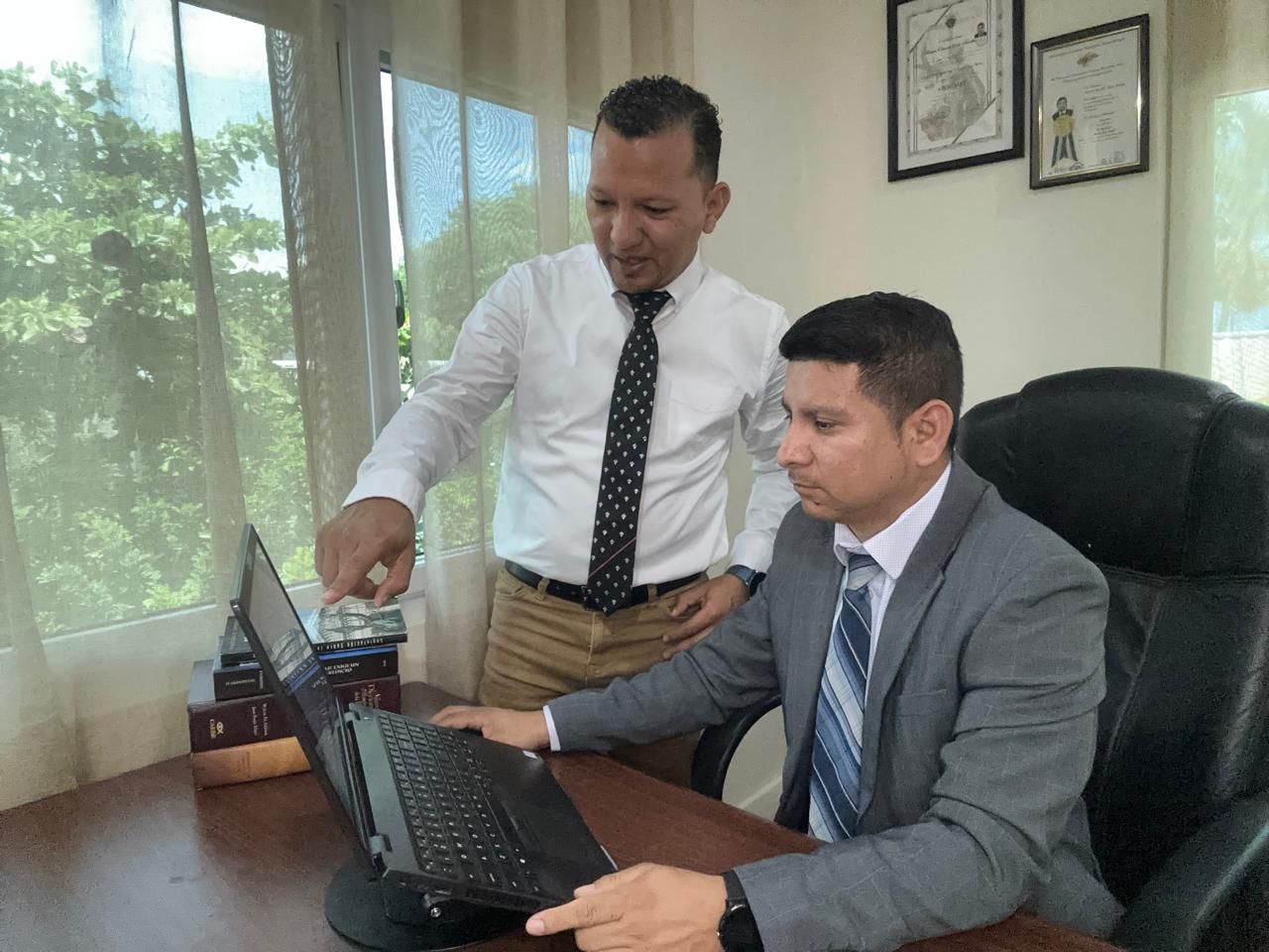 Marvin Sorto y Delmer Ramos revisando un expediente en la oficina de Legacy Consultor&iacute;a